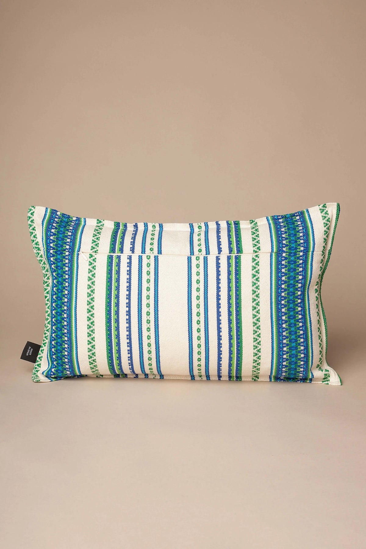 Funda de cojín rectangular con tejido manchego, rayas verticales en verde, azul y crema, textura artesanal y rústica.