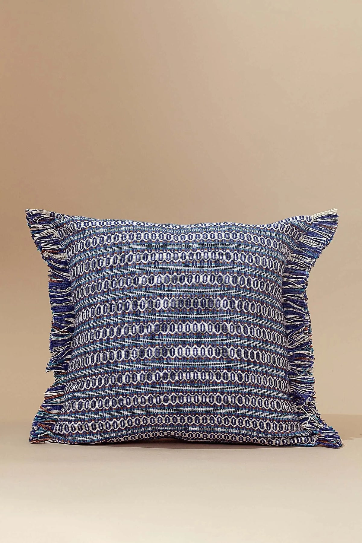 Funda de cojín azul 45x45cm con tejido ojo de perdiz, estilo retro y bordes con flecos decorativos en tonos variados.
