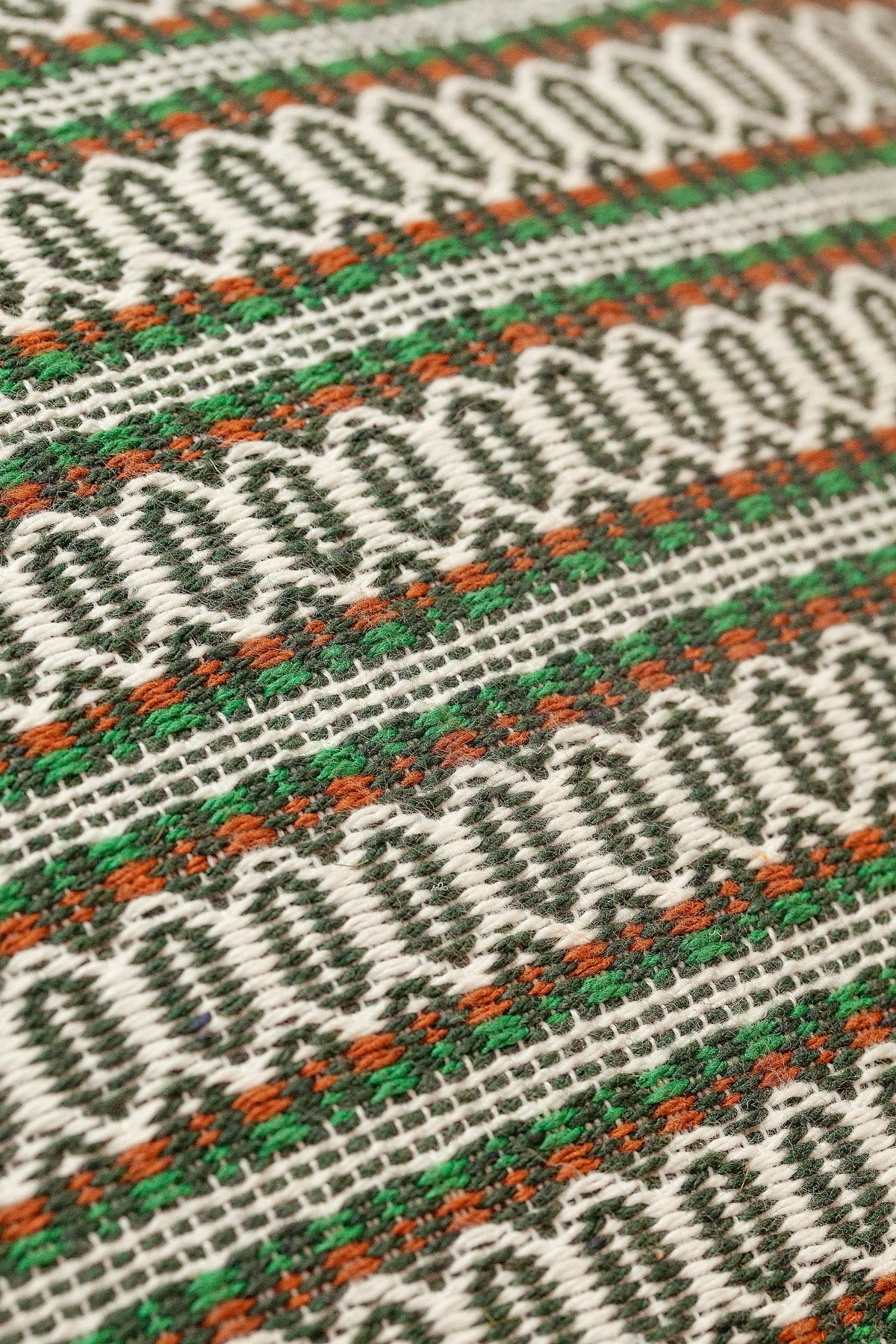 Funda de cojín con tejido retro, patrón geométrico en verde, blanco y naranja, textura estilo ojo de perdiz.