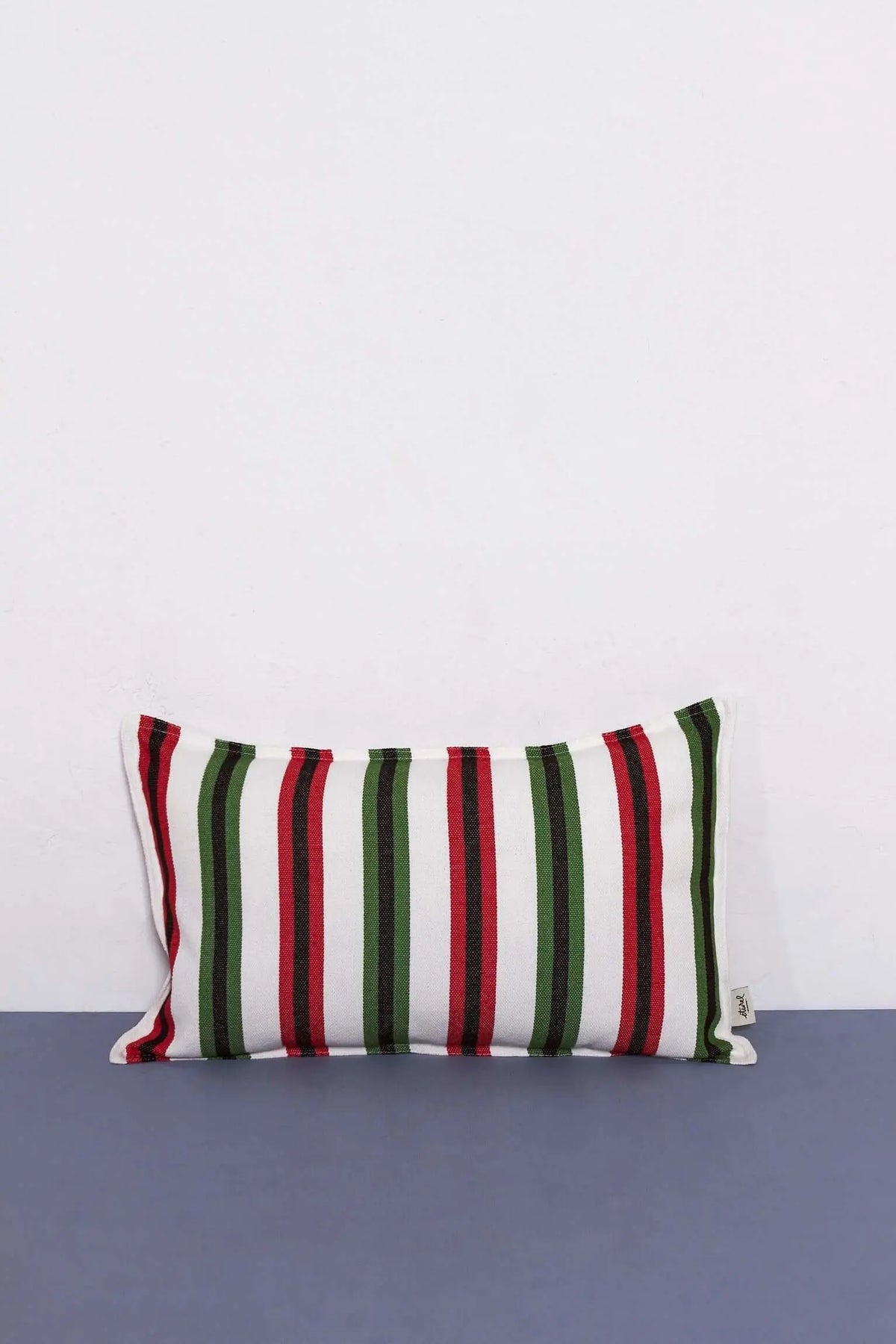 Funda de cojín rectangular 30x50 cm con tejido canario a rayas verticales en verde, rojo y negro sobre fondo blanco.