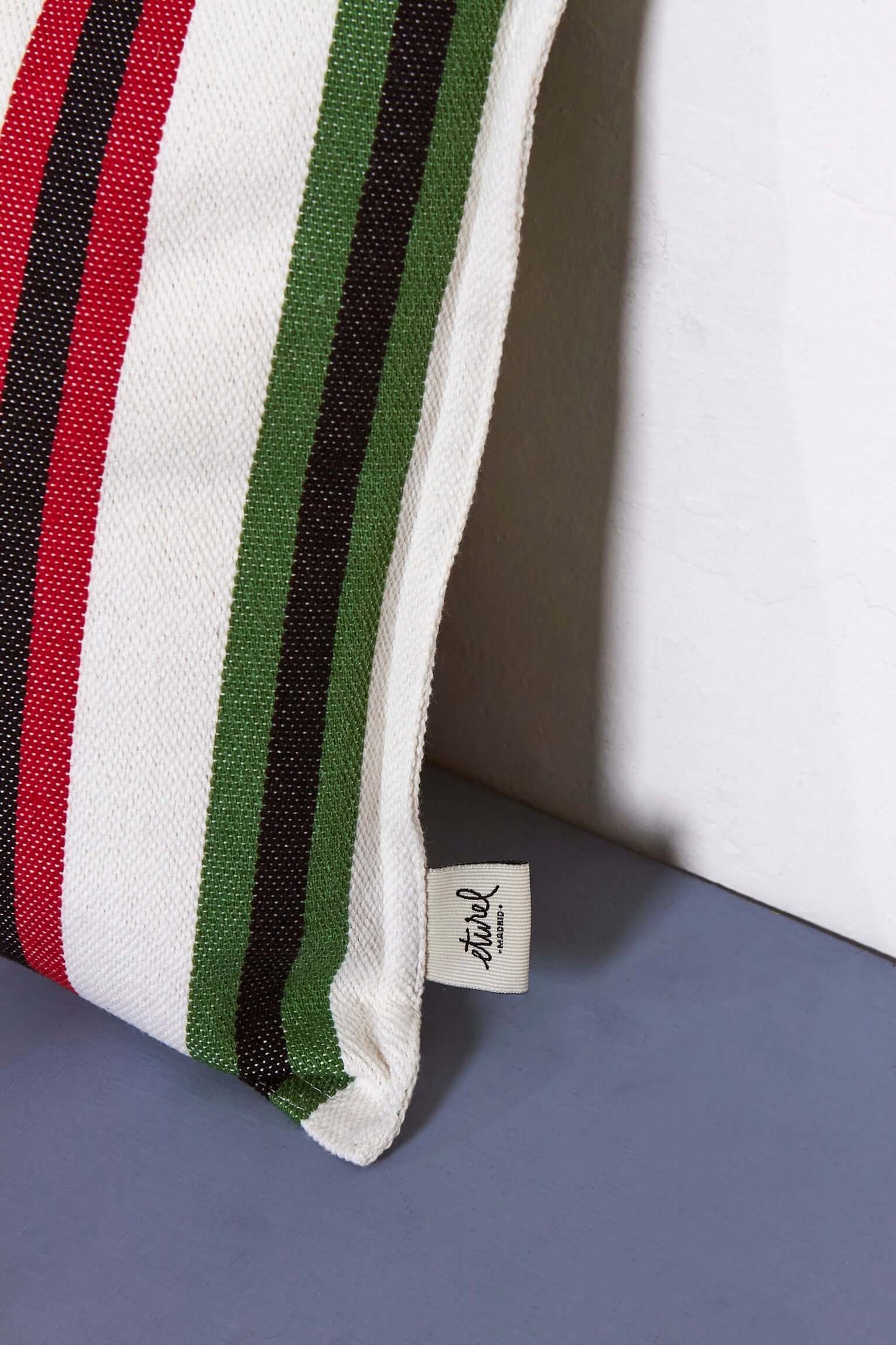 Rectangular 30x50cm woven cushion cover with red, green, and dark brown vertical stripes on an off-white background.