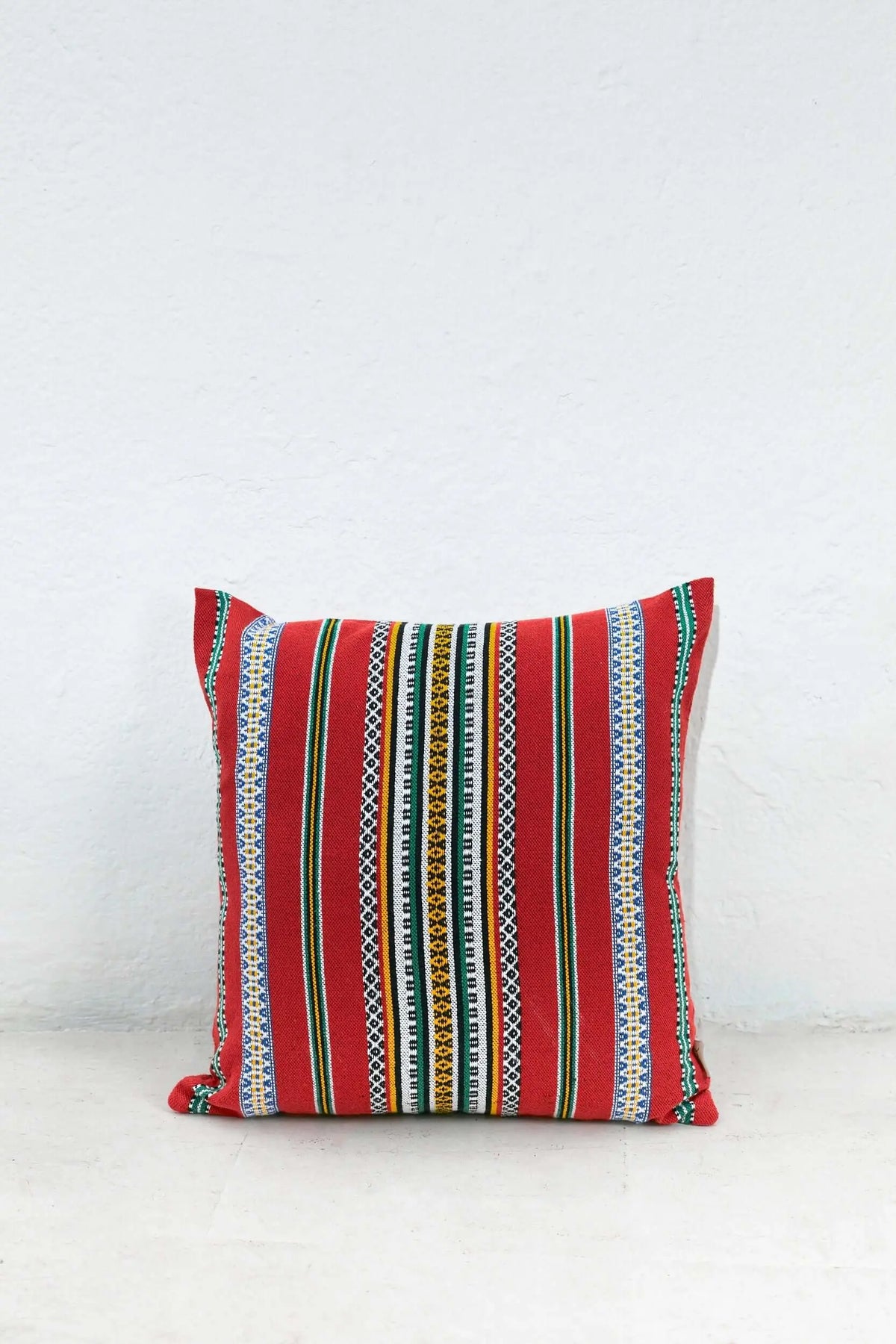Funda de cojín rectangular de 50x45cm en color rojo con diseño de rayas verticales multicolores y tejido artesanal.