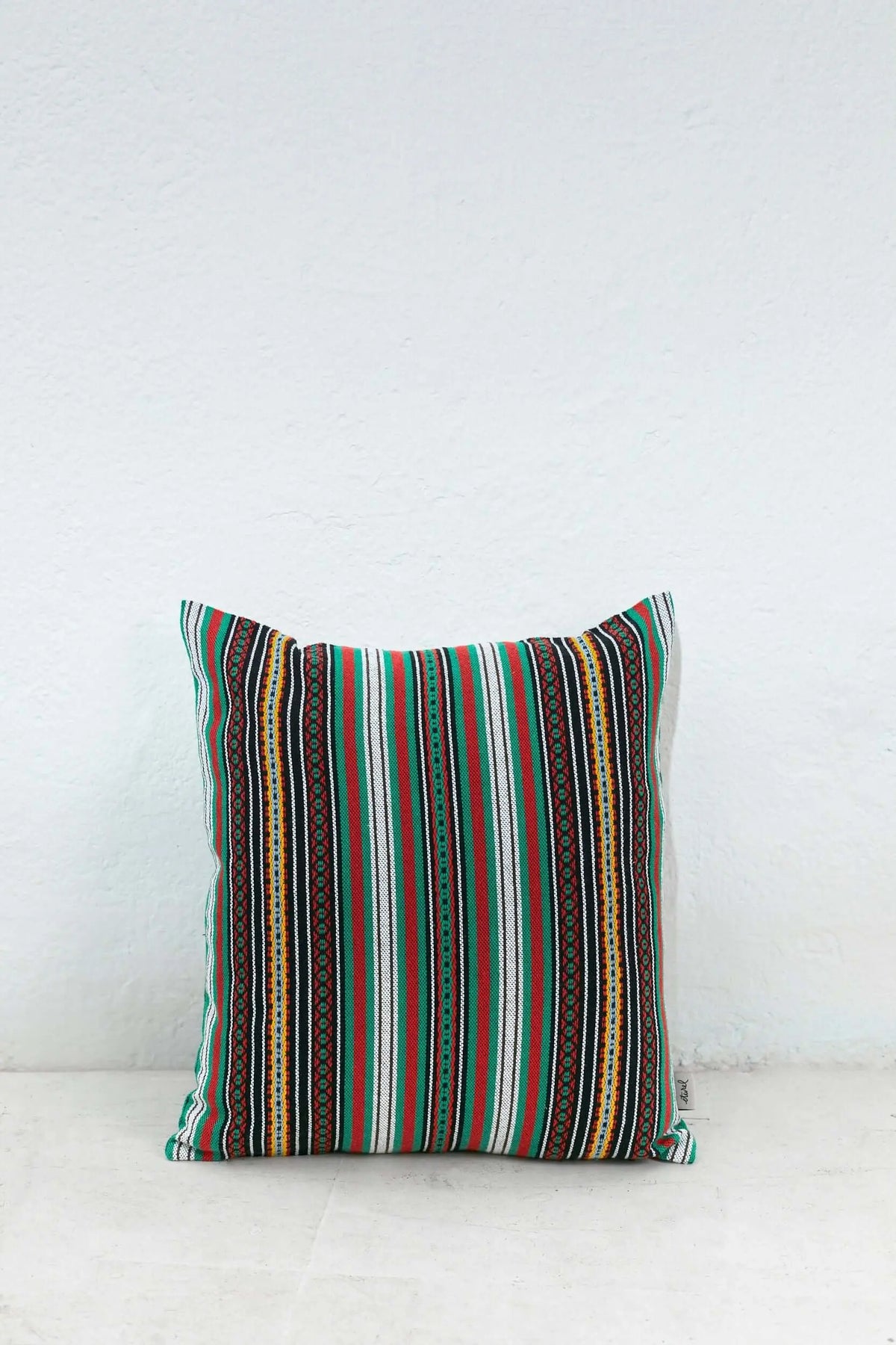 Square cushion cover with vibrant vertical stripes in green, red, black, white, and yellow ethnic patterns.