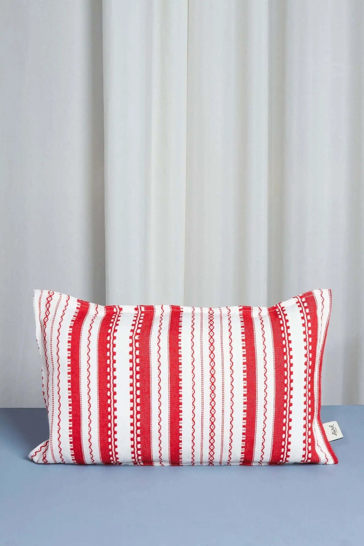 Funda rectangular (30x50cm) de tejido blanco con rayas verticales rojas y motivos geométricos bordados tipo alpujarra.