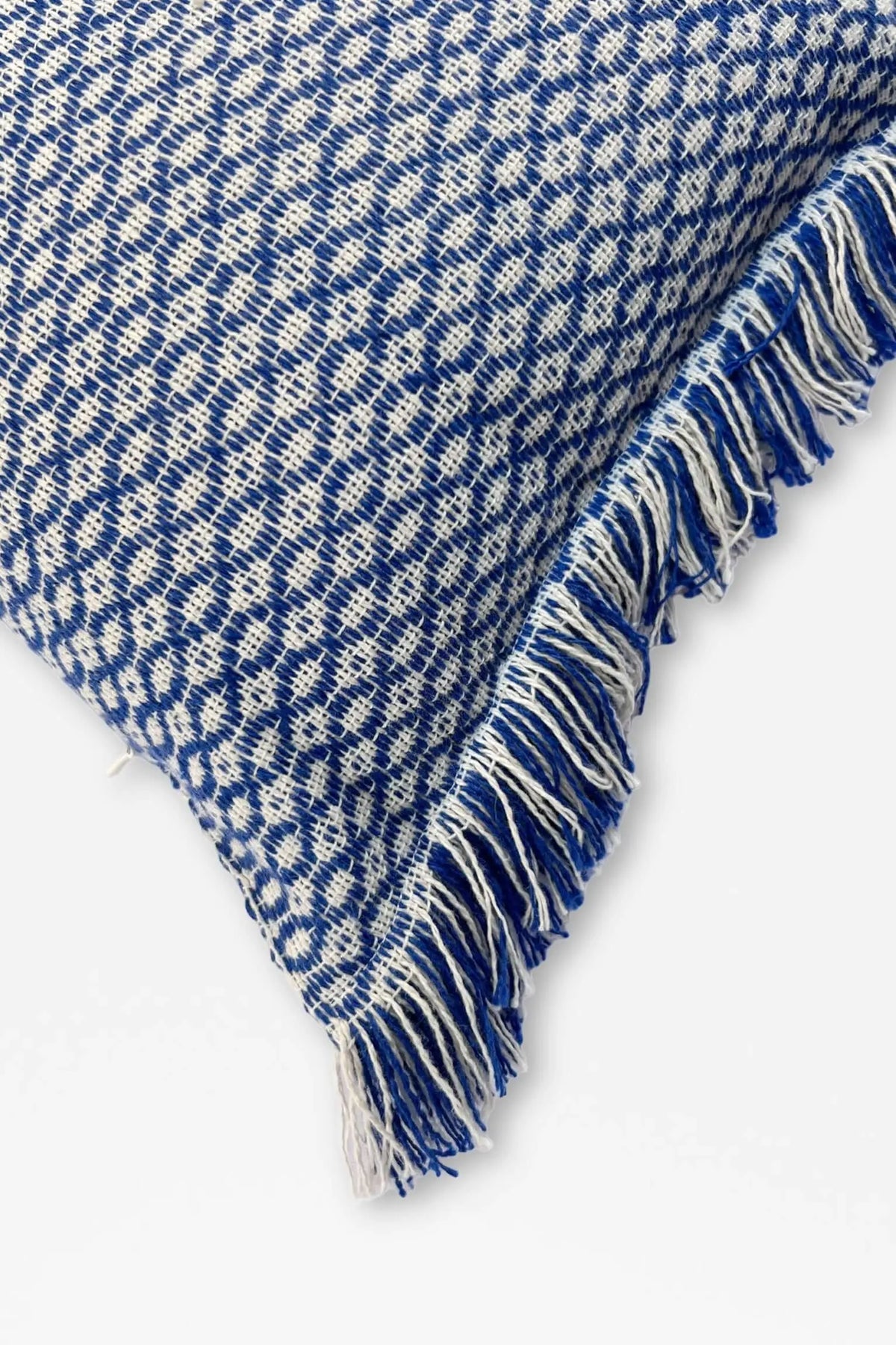 Rectangular blue and white houndstooth pattern cushion cover with fringed edges and a textured woven fabric.