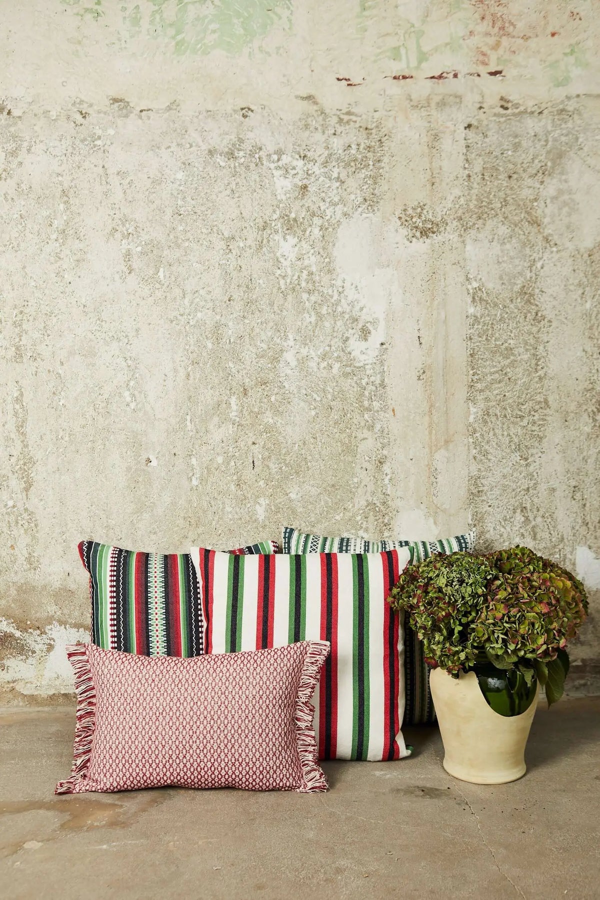 Rectangular maroon cushion with fringed edges and a textured "ojo de perdiz" (houndstooth-like) pattern.