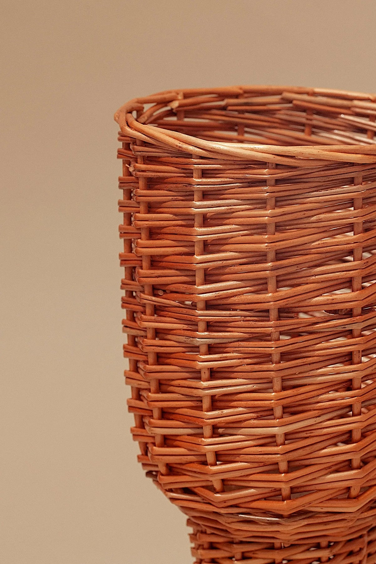 Jarrón pequeño de mimbre natural con tejido artesanal en tonos marrones cálidos, diseño rústico y minimalista.