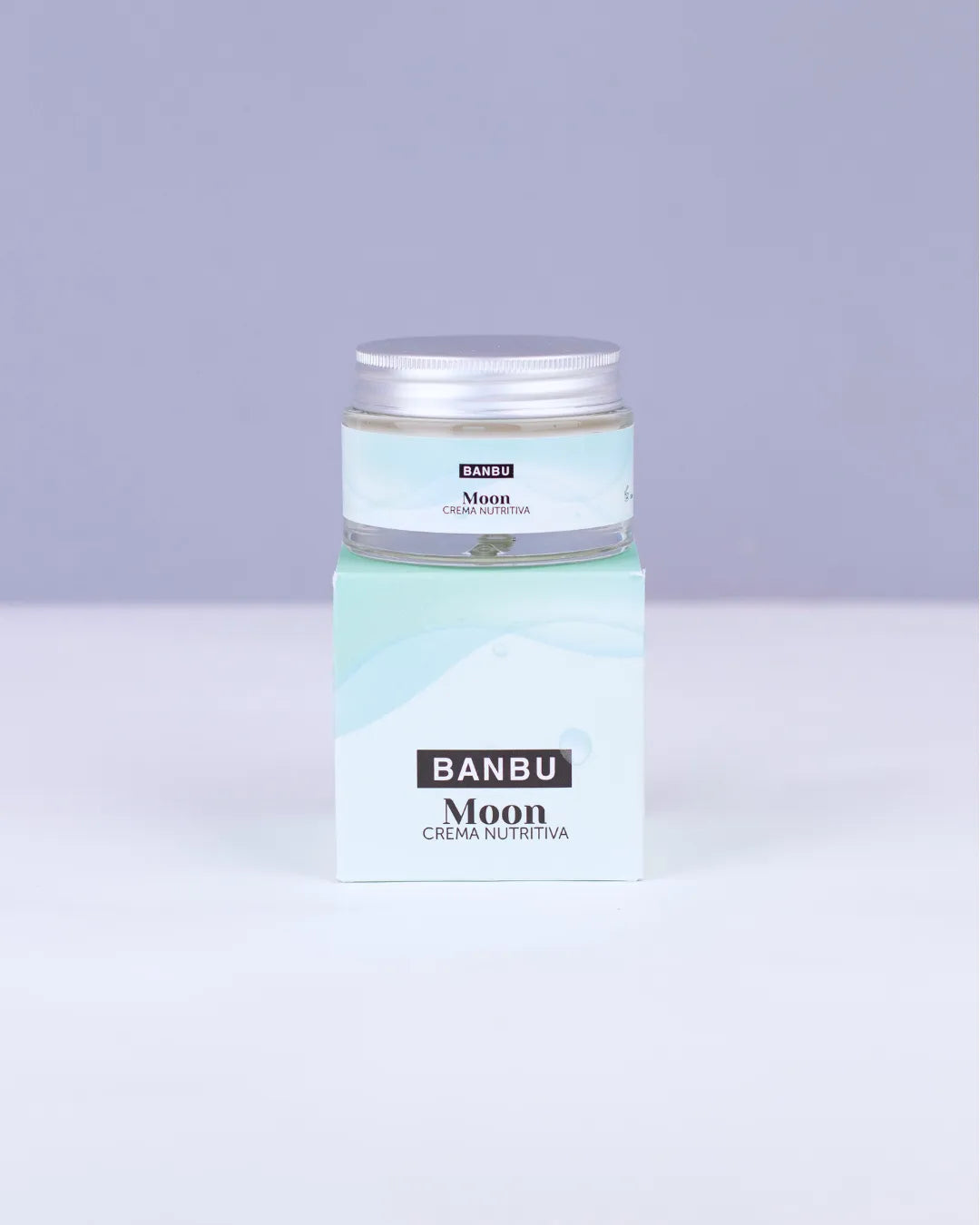 Crema facial nutritiva Banbu Moon en tarro de cristal con tapa metálica sobre su caja de cartón en tonos azul pastel.