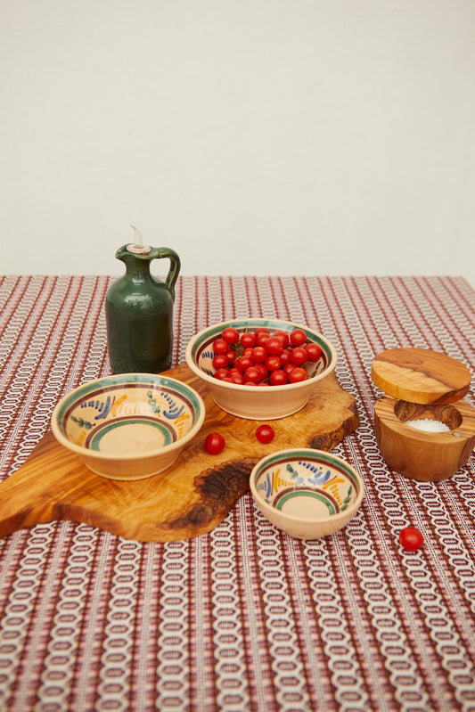 Set of three ceramic bowls with hand-painted blue, yellow, and green floral patterns on a natural cream background.