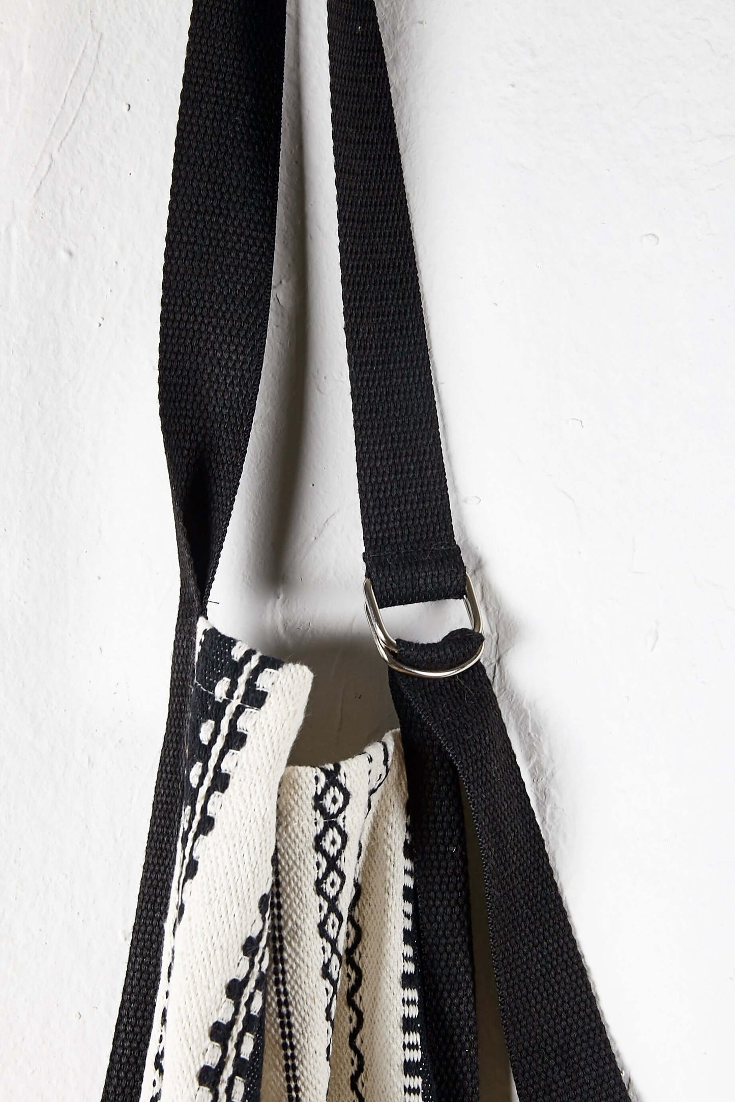 Detalle de anilla metal ajustable en cuello de delantal alpujarra blanco negro con rayas verticales