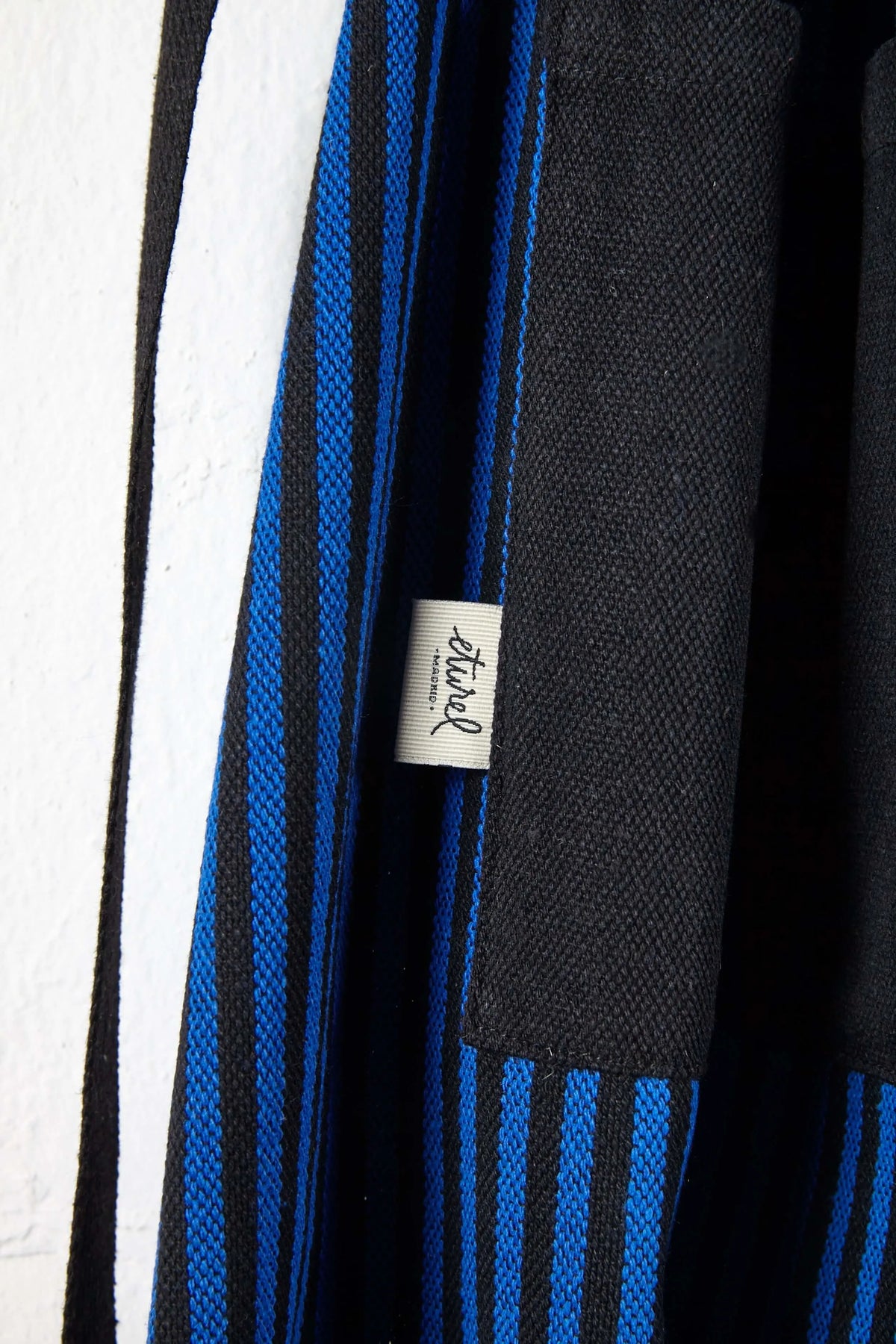 Delantal de loneta con diseño de rayas verticales azules y negras y textura resistente.