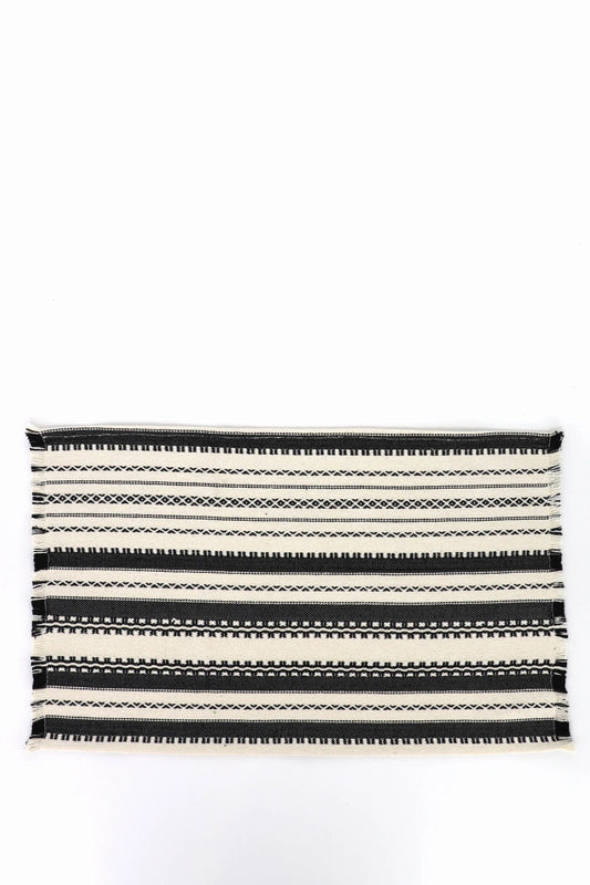 Pack de dos manteles individuales de algodón estilo alpujarra con rayas geométricas en blanco y negro y bordes deshilados.