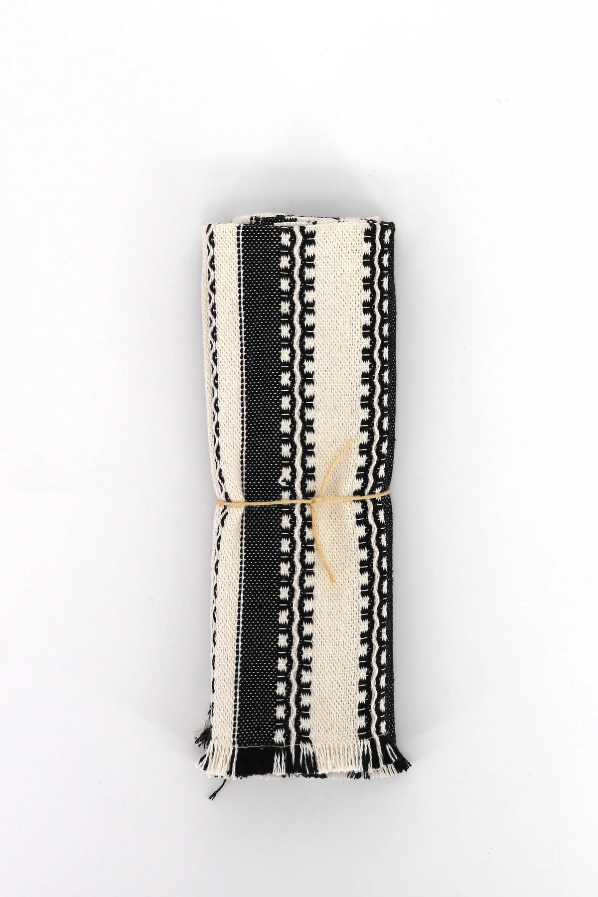Pack de 2 manteles individuales de tela tipo alpujarra con rayas y motivos geométricos en blanco y negro con flecos.