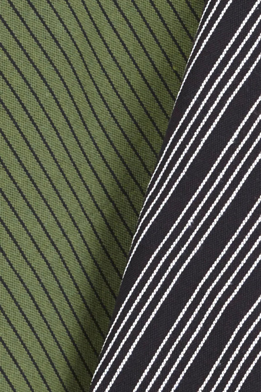 Dos paños de cocina de loneta con diseño de rayas diagonales, uno en verde oliva y otro en negro con líneas blancas.