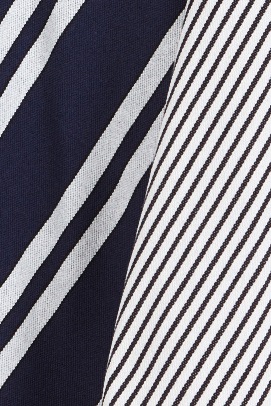 Two dish towels featuring blue and white diagonal stripes in both wide and thin variations on textured fabric.
