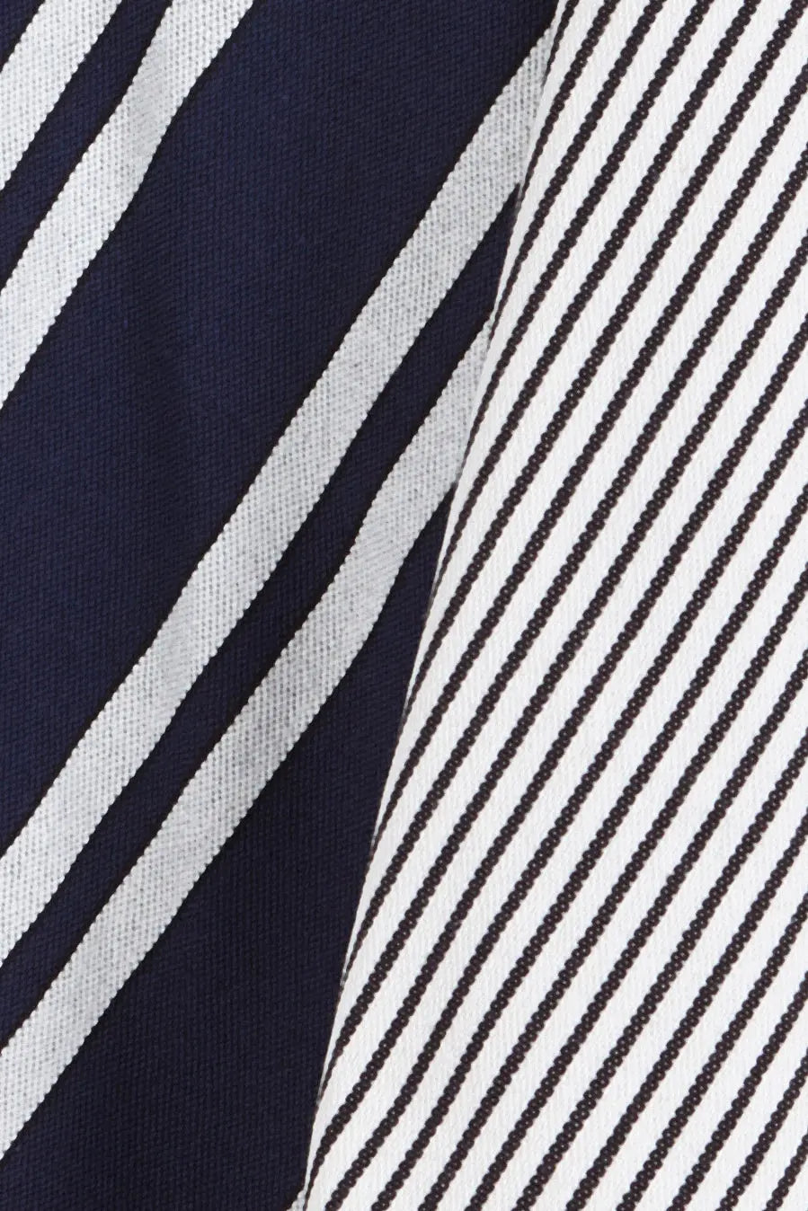 Two dish towels featuring blue and white diagonal stripes in both wide and thin variations on textured fabric.