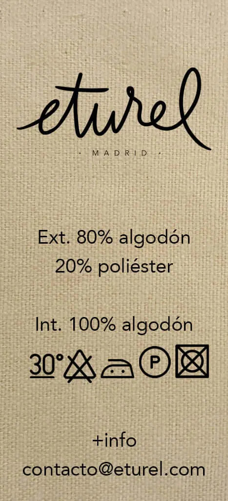 Etiqueta de composición de funda de cojín: 80% algodón, 20% poliéster, con instrucciones de lavado sobre tejido beige.