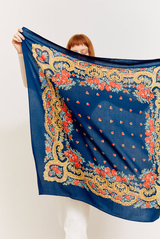 Pañuelo azul marino con estampado floral rojo y detalles dorados en estilo ornamental clásico y tradicional.