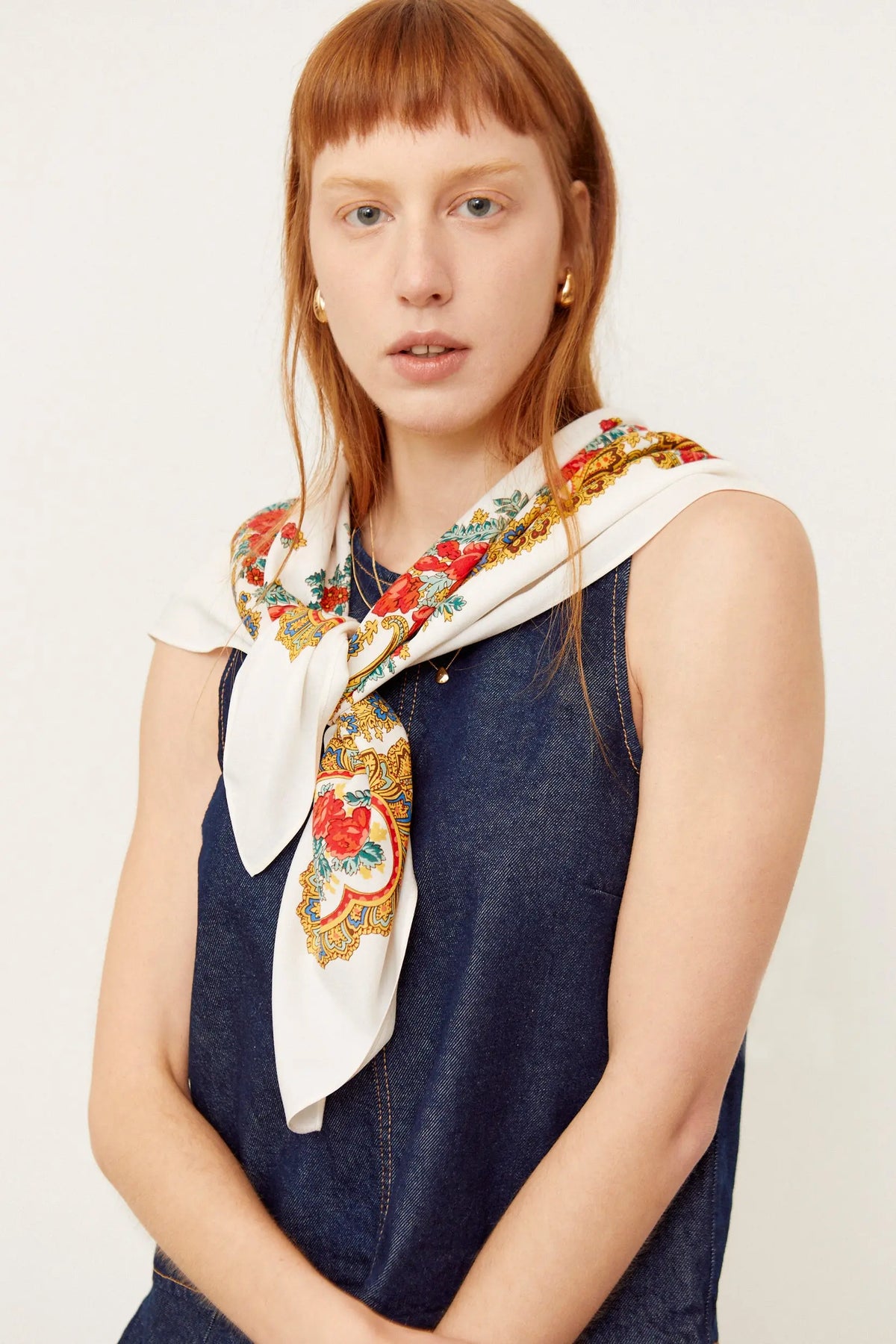 Pañuelo blanco de estilo clásico con estampado floral, motivos de cadenas doradas y detalles en rojo, azul y verde.