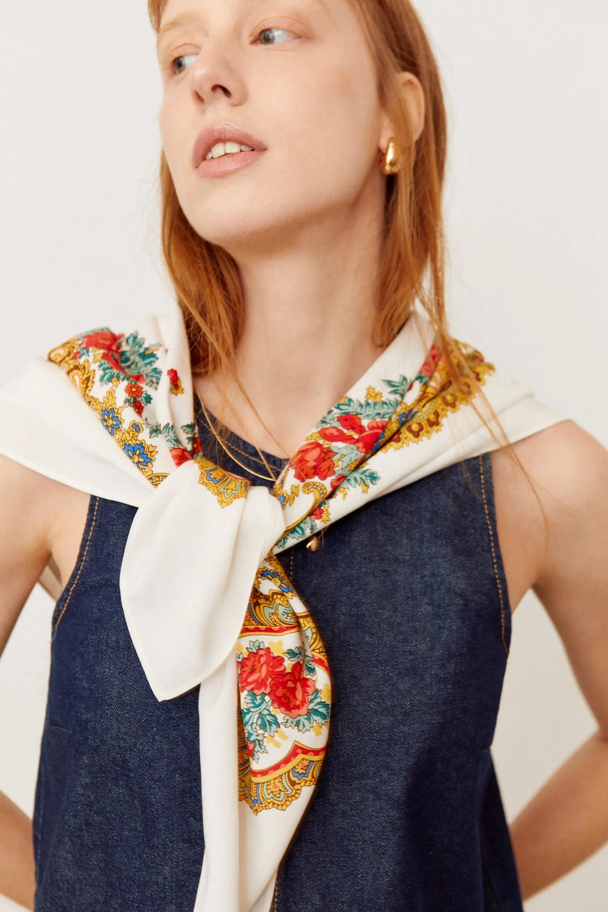 Pañuelo blanco con estampado floral multicolor en estilo tradicional portugués anudado al cuello.