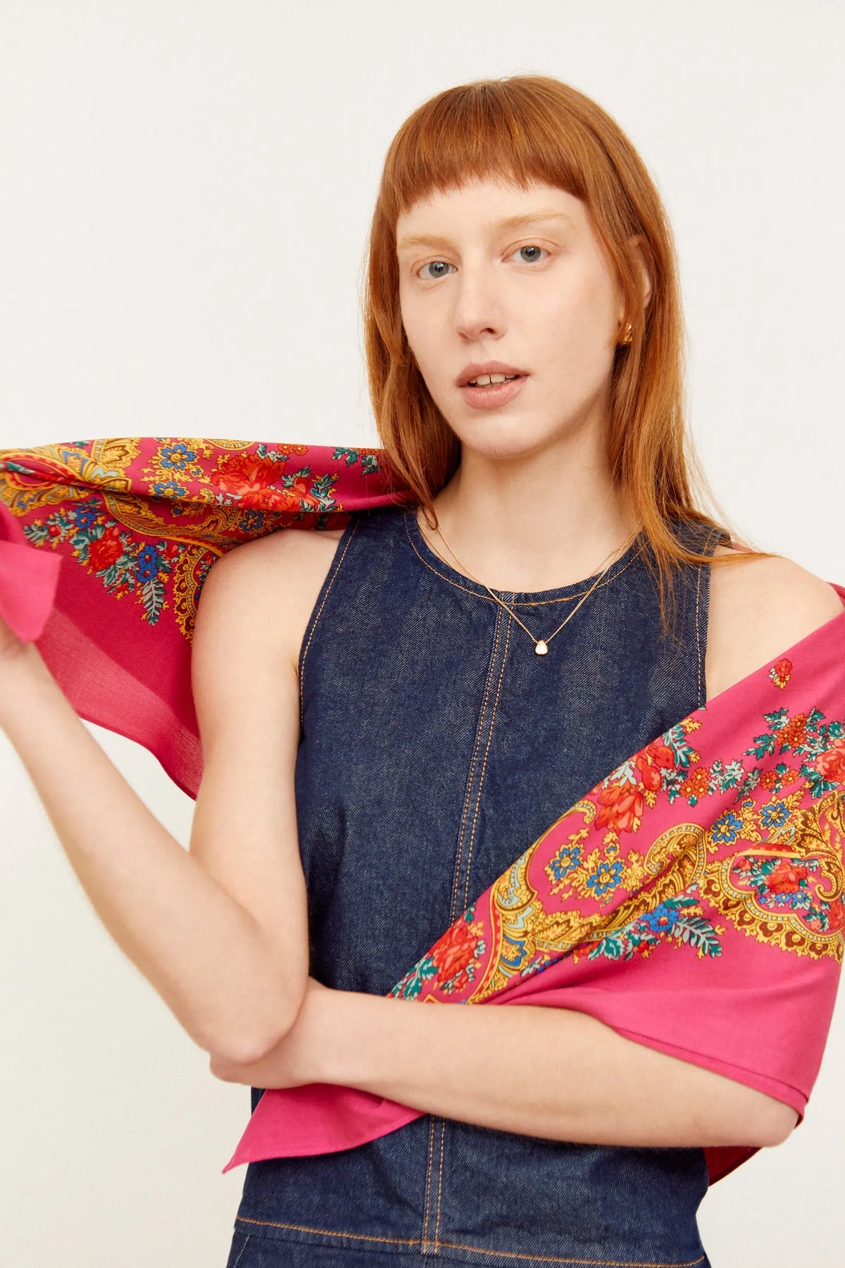 Pañuelo de estilo portugués en rosa intenso con estampado floral y de cadenas en tonos rojos, azules y dorados.
