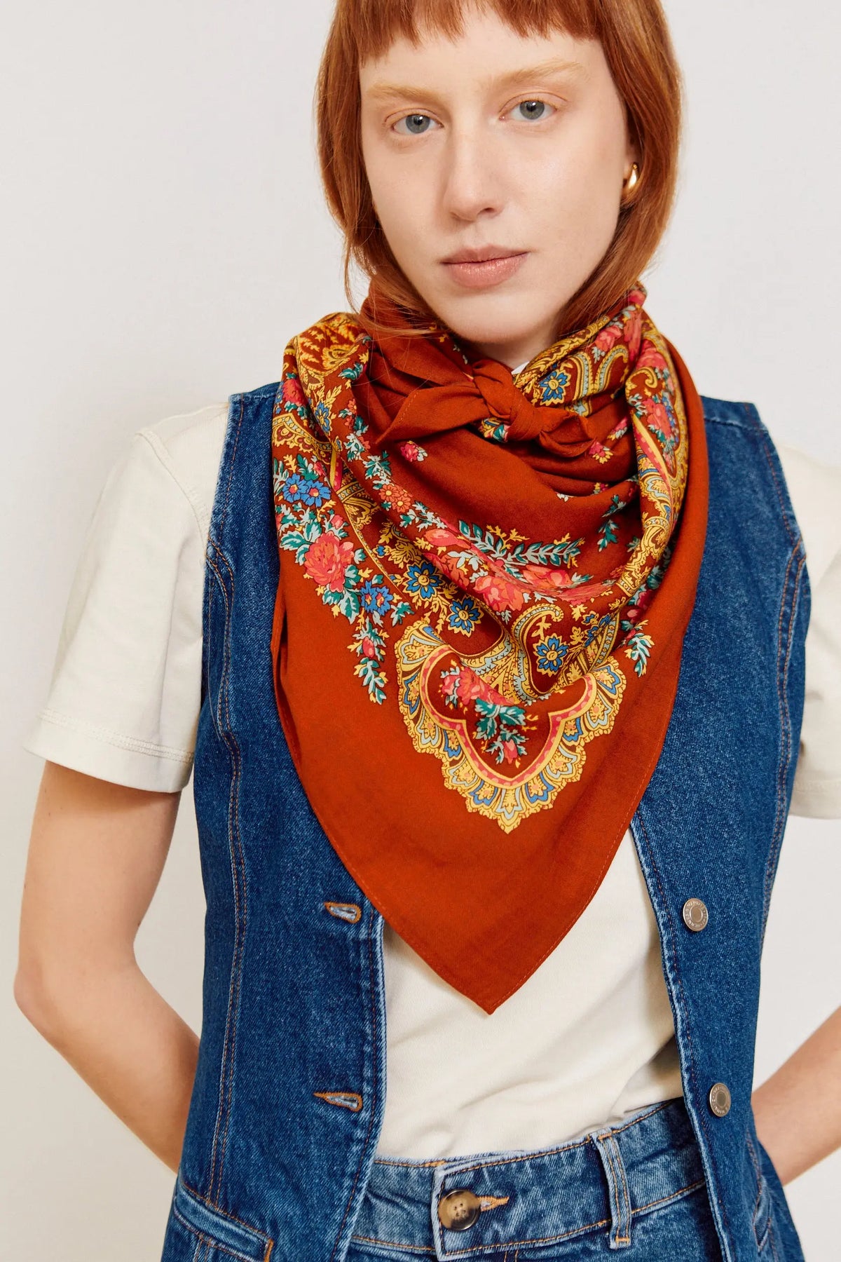 Rust-colored Portuguese scarf featuring an ornate floral and chain-link pattern in vibrant blue, red, and gold.
