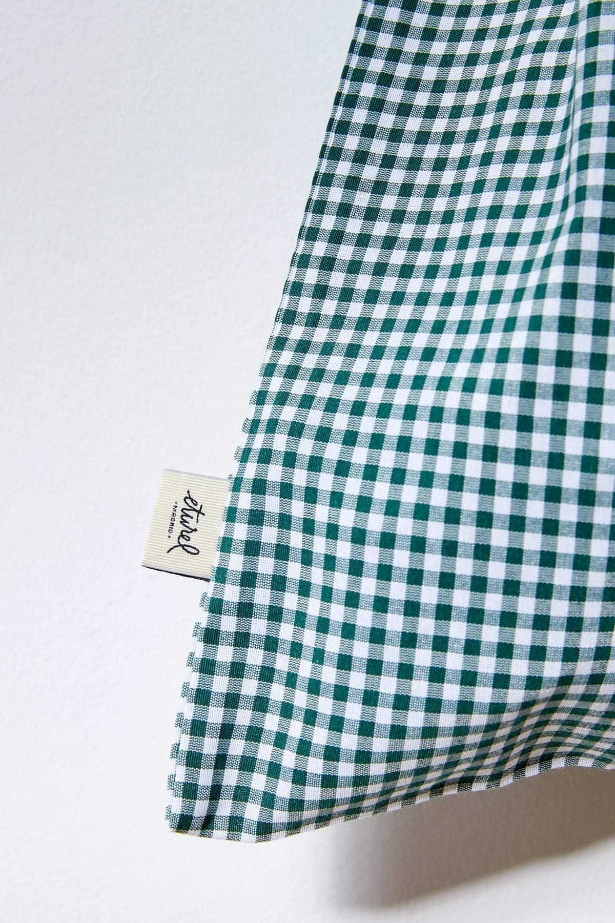 Panera de tela con estampado de cuadros vichy en verde y blanco sobre fondo neutro.