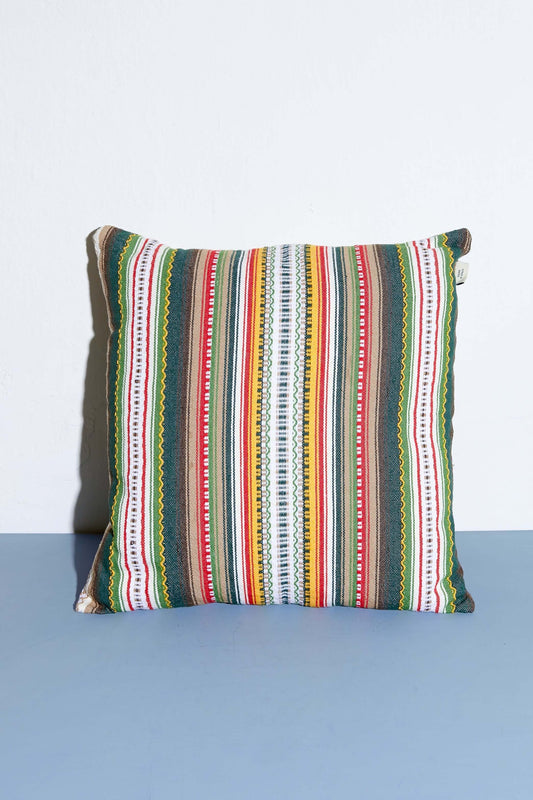 Cojín cuadrado de 50x50cm con diseño de rayas verticales multicolores en tejido tipo alpujarra de estilo artesanal.