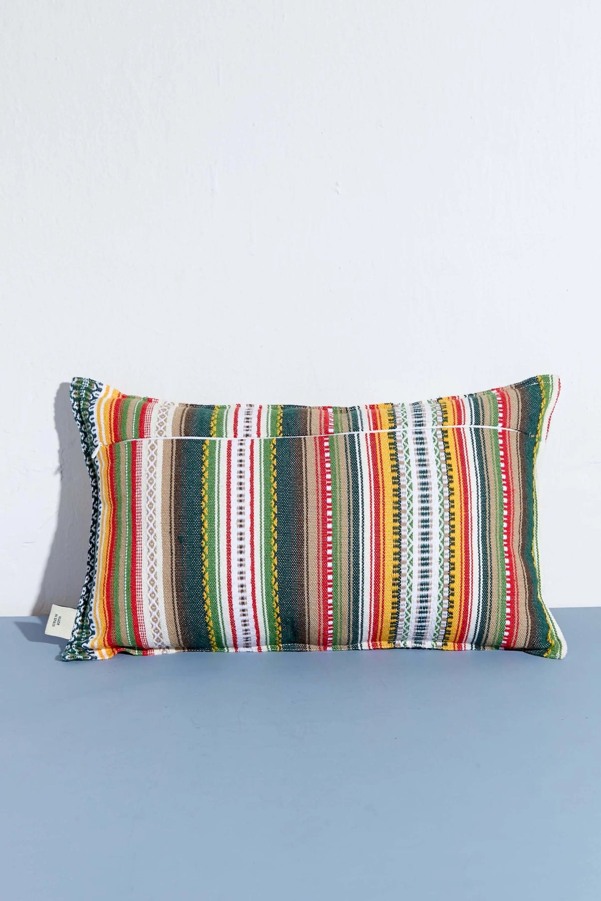 Funda de cojín rectangular 30x50 cm estilo alpujarra con rayas verticales multicolores y textura de tejido tradicional.