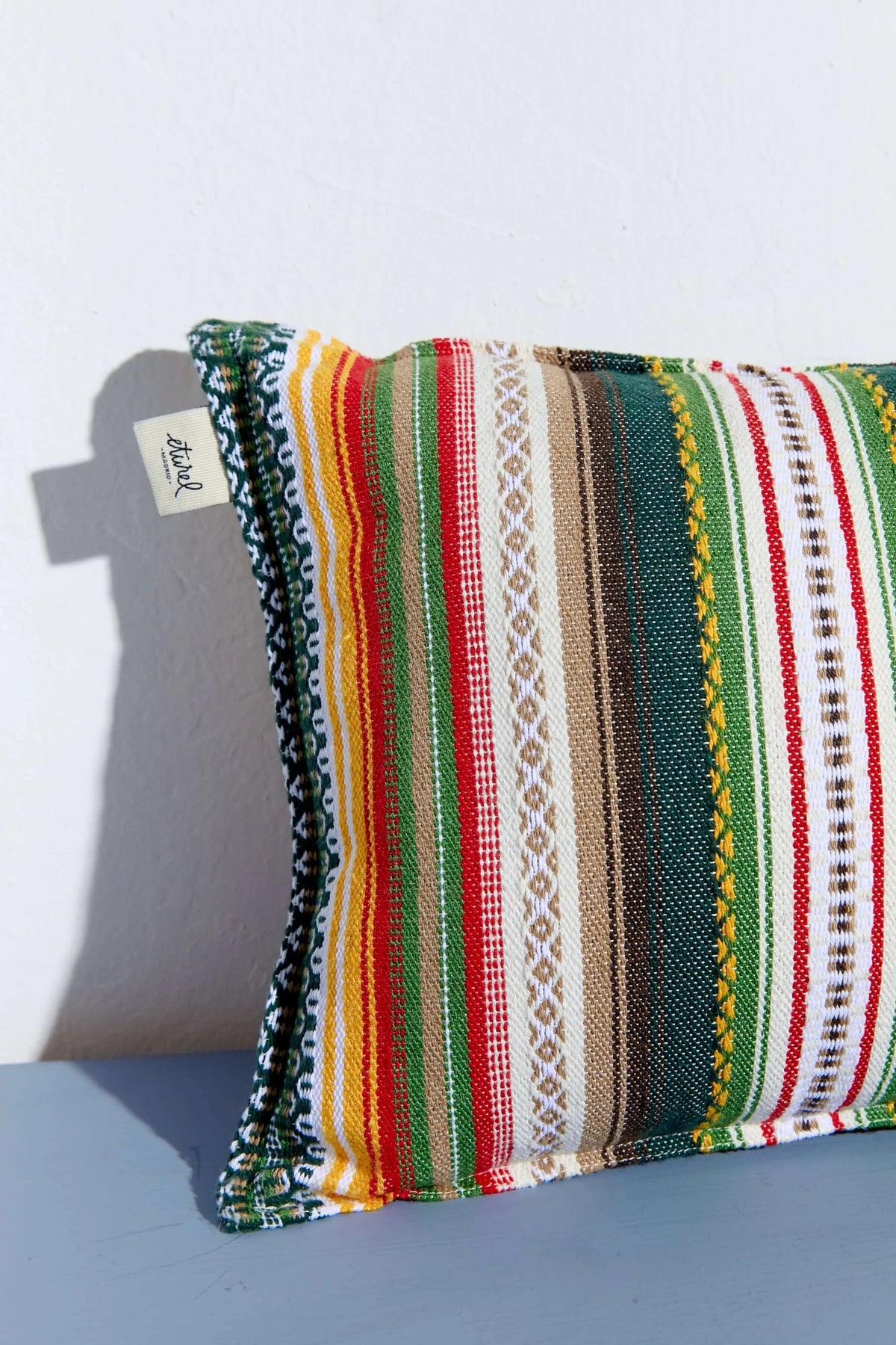 Funda de cojín rectangular estilo alpujarreño con rayas verticales multicolor y textura tejida artesanal, 30x50 cm.