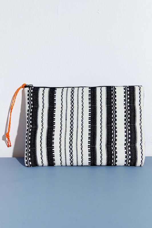 Funda para ordenador o tablet de estilo alpujarra con estampado de rayas verticales en blanco y negro y tirador naranja.
