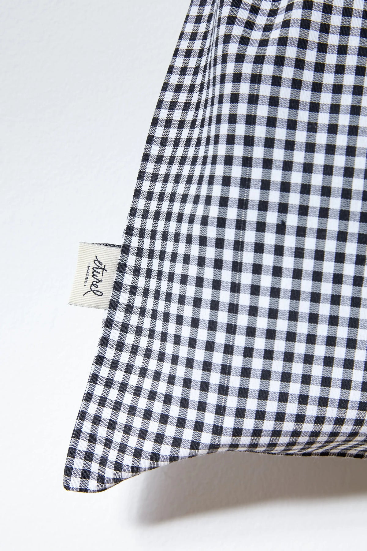 Panera de tela con estampado de cuadros vichy azul marino y blanco, de forma rectangular y textura de algodón.