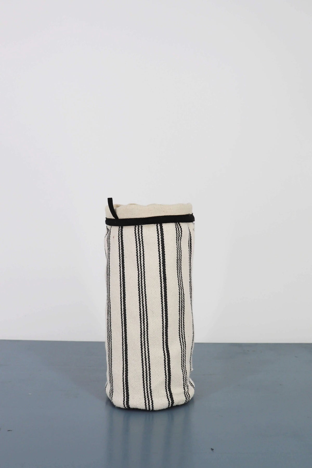 Cylindrical vase cover in white canvas with vertical black stripes and a black trim detail around the top edge.