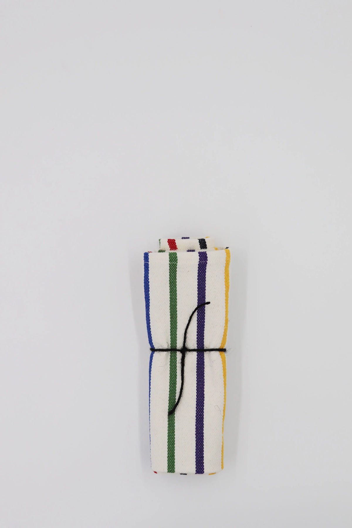 Two folded fabric napkins with a cream background and vertical multi-colored stripes, tied together with black twine.