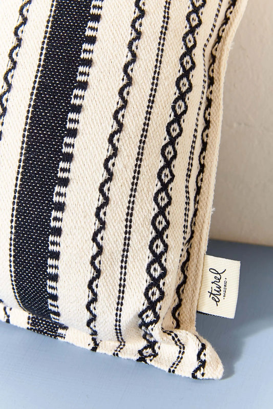 Rectangular cushion cover with a black and white striped Alpujarra-style woven fabric pattern and a fabric brand tag.