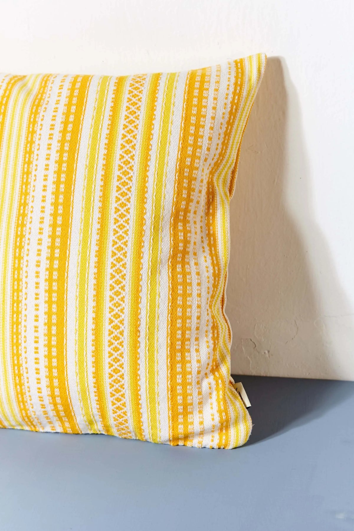 Square cushion cover in yellow and white, featuring a traditional Alpujarra woven striped pattern.