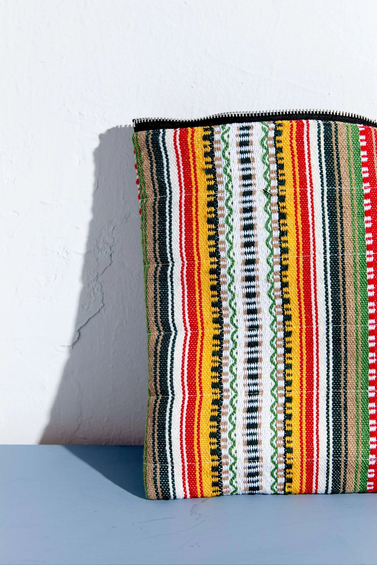 Funda para portátil o tablet de tejido alpujarreño con rayas verticales multicolor y cierre de cremallera superior.