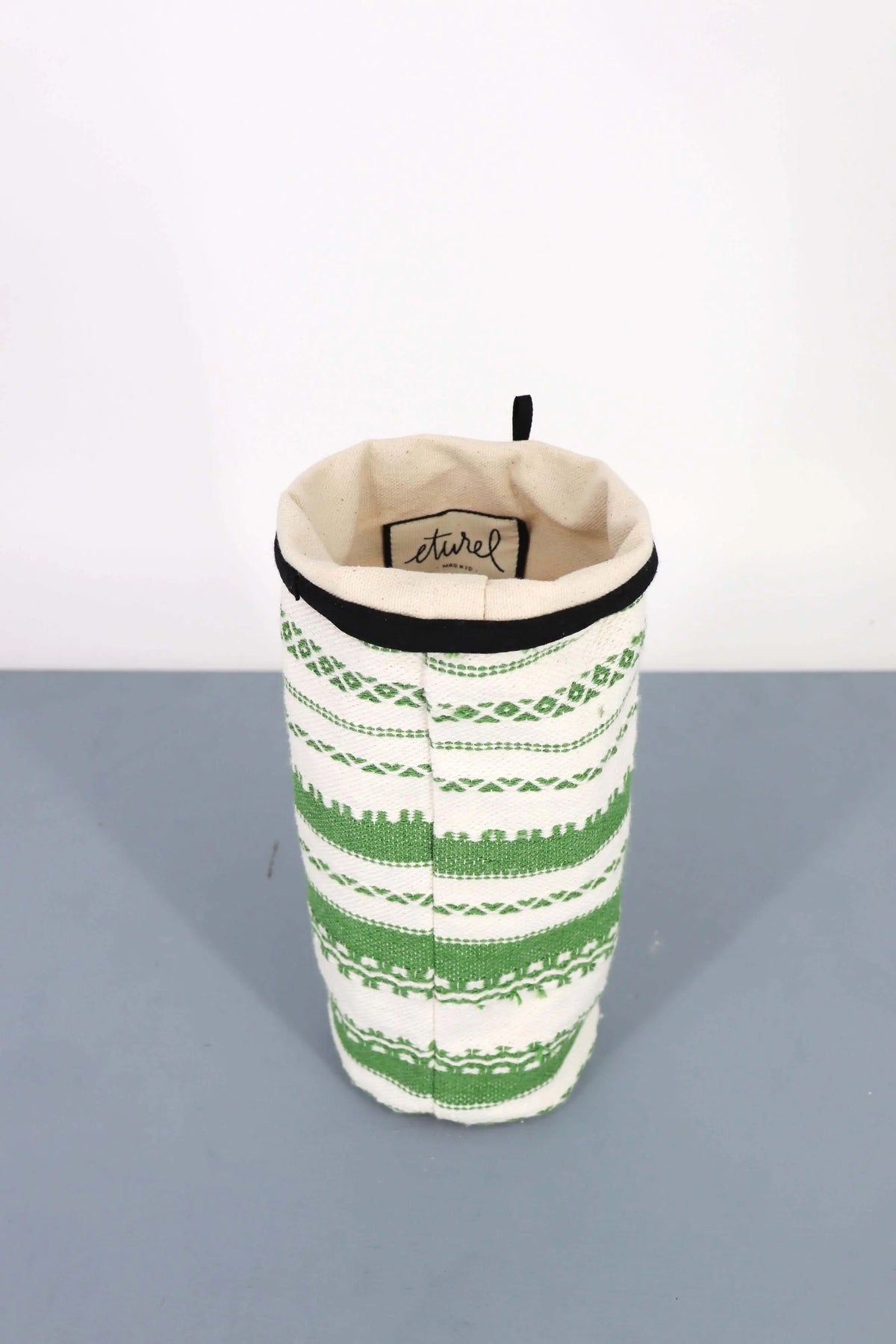 Funda para jarrón de tela con tejido artesanal en rayas verdes y blancas, estilo rústico y borde superior negro.