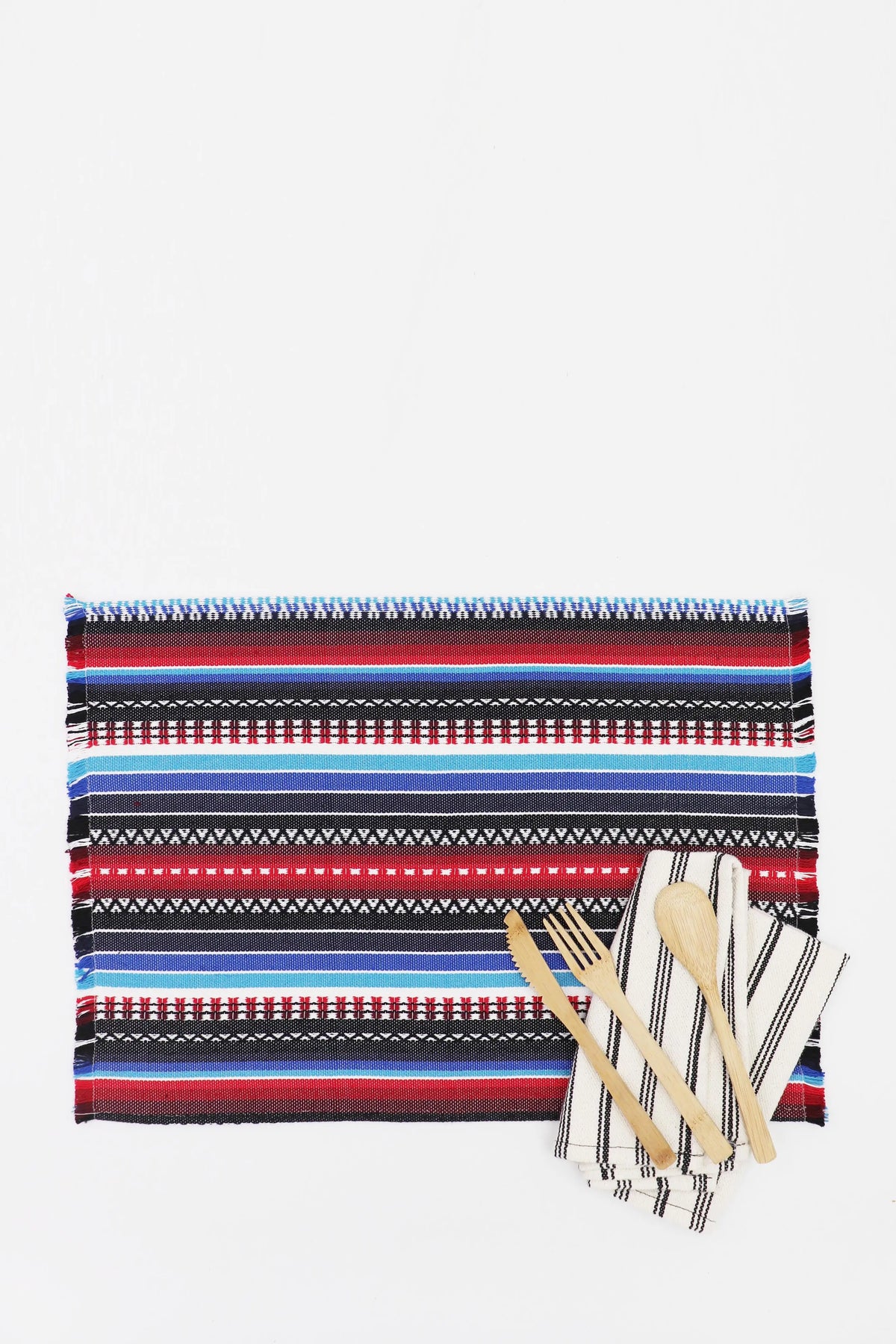 Pack de 2 manteles individuales tejidos en azul, rojo y negro con patrón geométrico, flecos y cubiertos de madera.