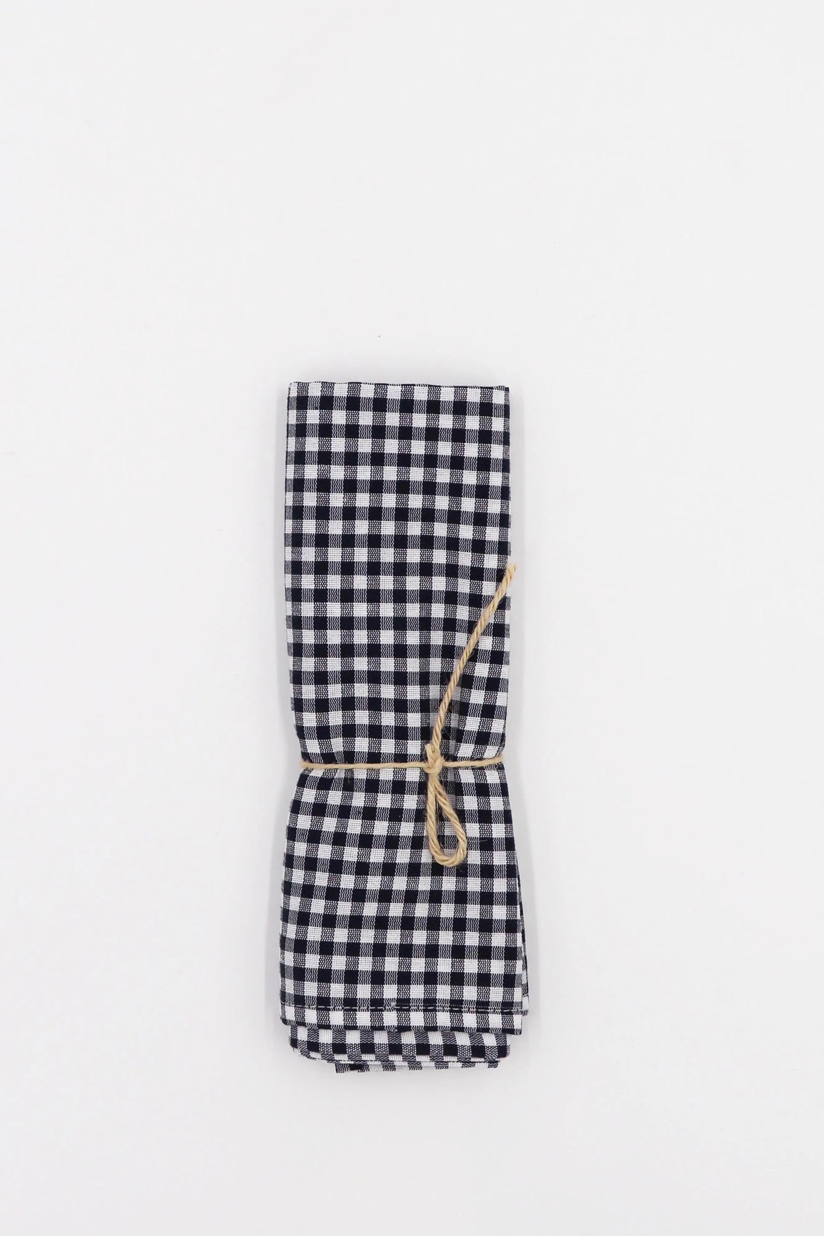 Pack de dos servilletas textiles con estampado de cuadros vichy en azul marino y blanco, atadas con una cuerda de yute.
