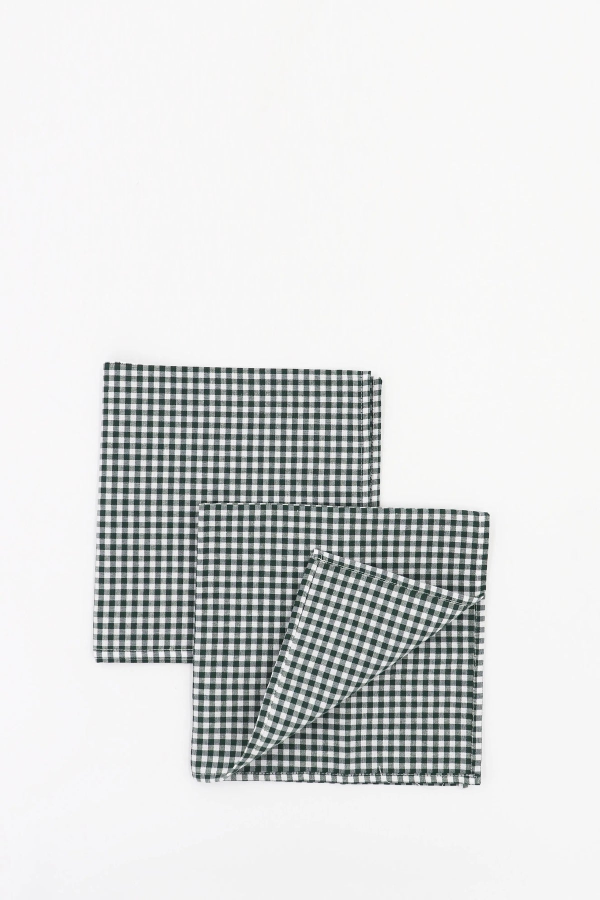 Pack de dos servilletas de tela con estampado de cuadros vichy en color verde oscuro y blanco sobre fondo neutro.
