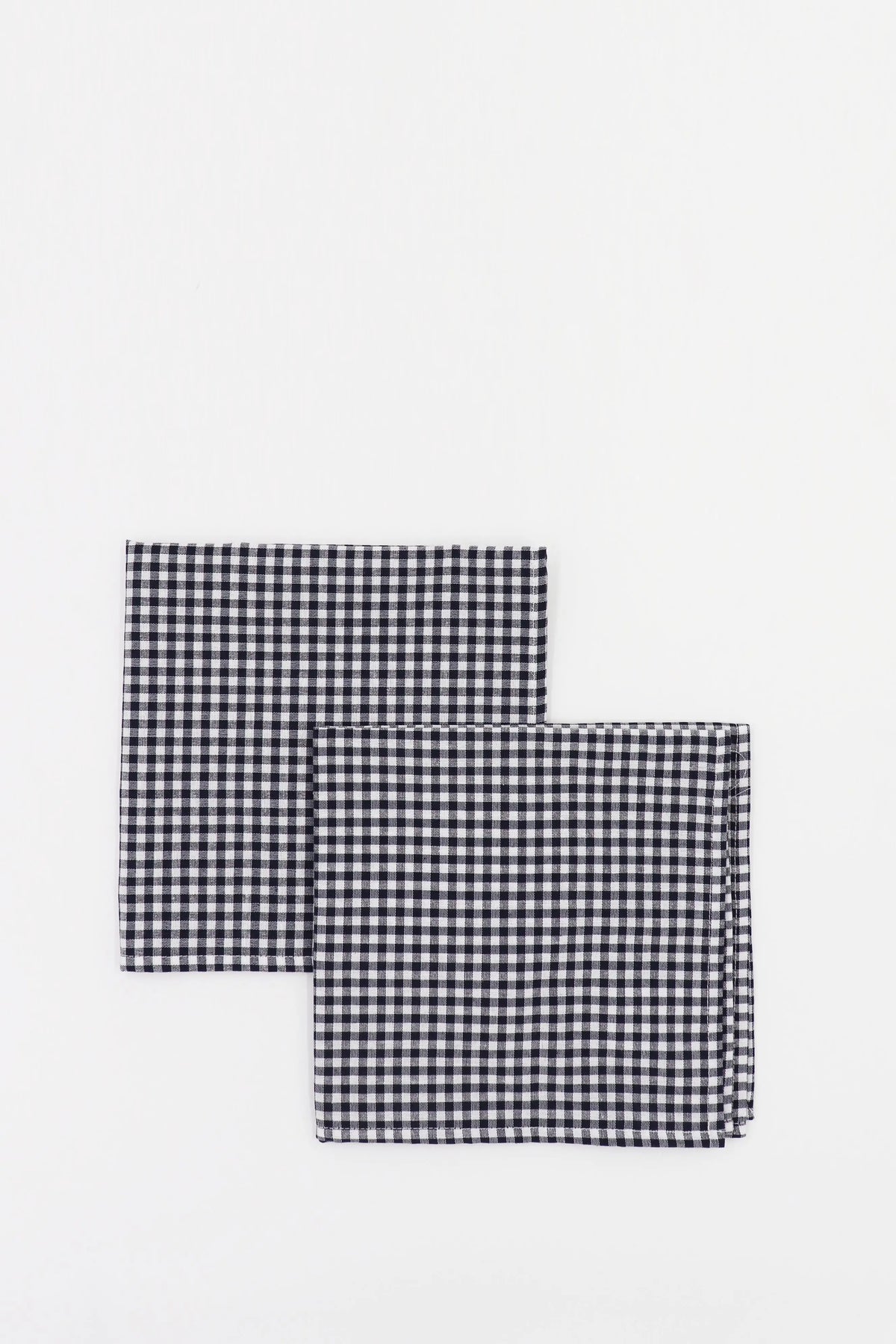Pack de dos servilletas cuadradas de tela con estampado vichy de cuadros pequeños en color azul marino y blanco.