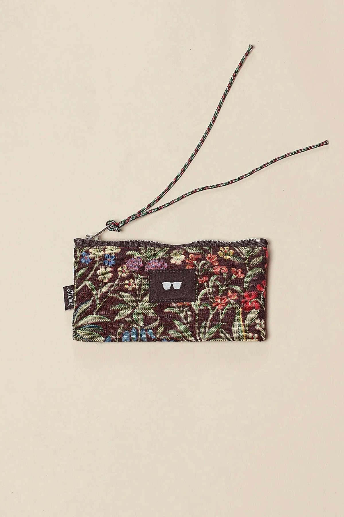 Funda de gafas en tejido jacquard marrón con estampado de flores coloridas, cierre de cremallera y cordón para colgar.
