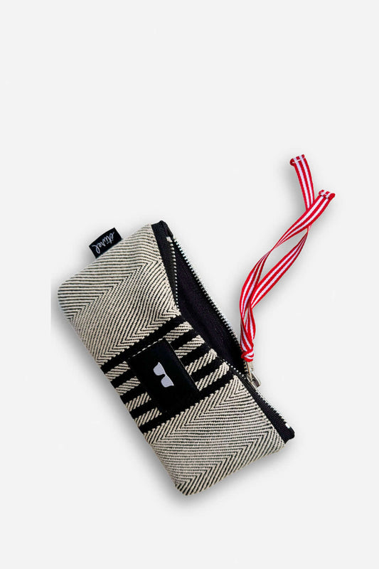 Funda de gafas de sarga con patrón de espiga en negro y beige, cierre de cremallera y cordón decorativo rojo y blanco.