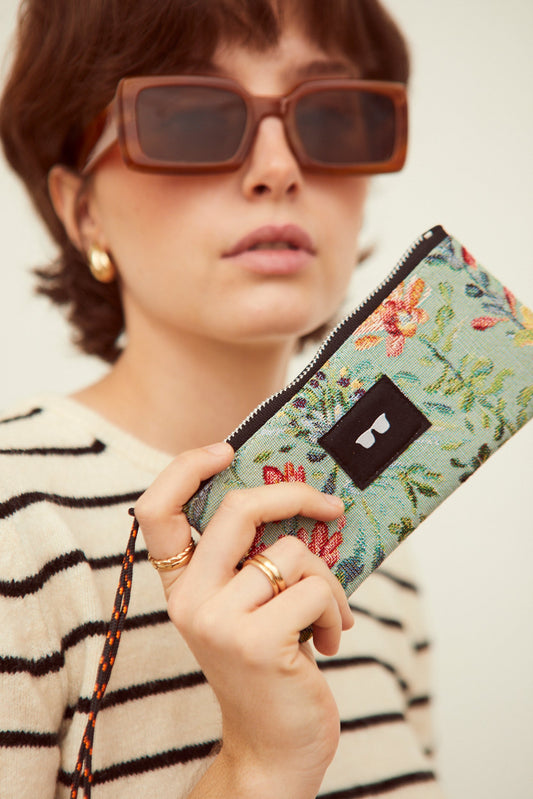 Funda de gafas en tejido jacquard con estampado de flores azaleas en tonos celestes, con cremallera y cordón ajustable.