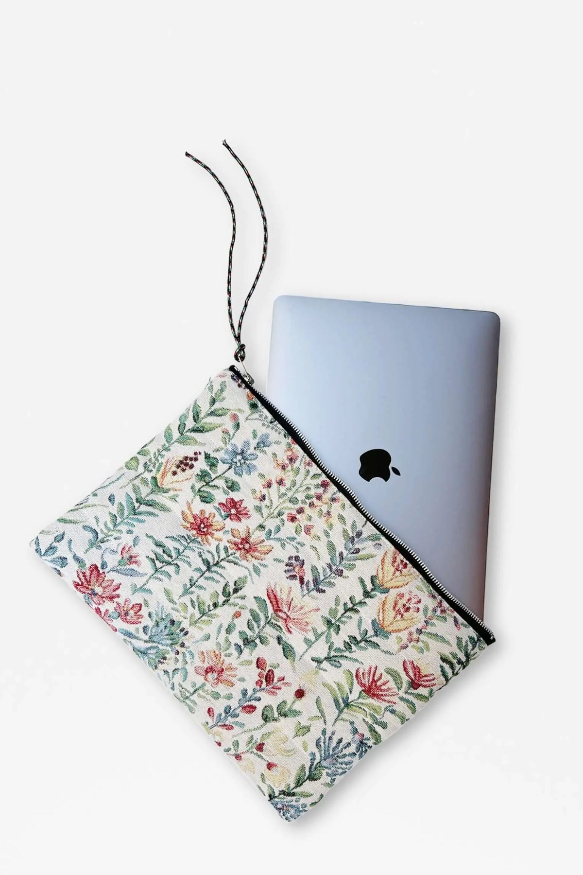 Laptop sleeve in cream jacquard fabric with a colorful floral azalea pattern, black zipper, and wrist strap.