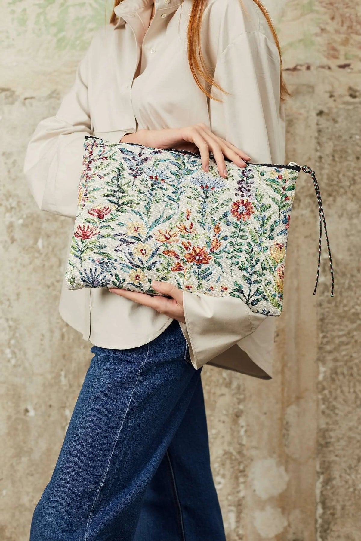 Funda para portátil en tejido jacquard color crema con estampado botánico de flores y hojas de colores.