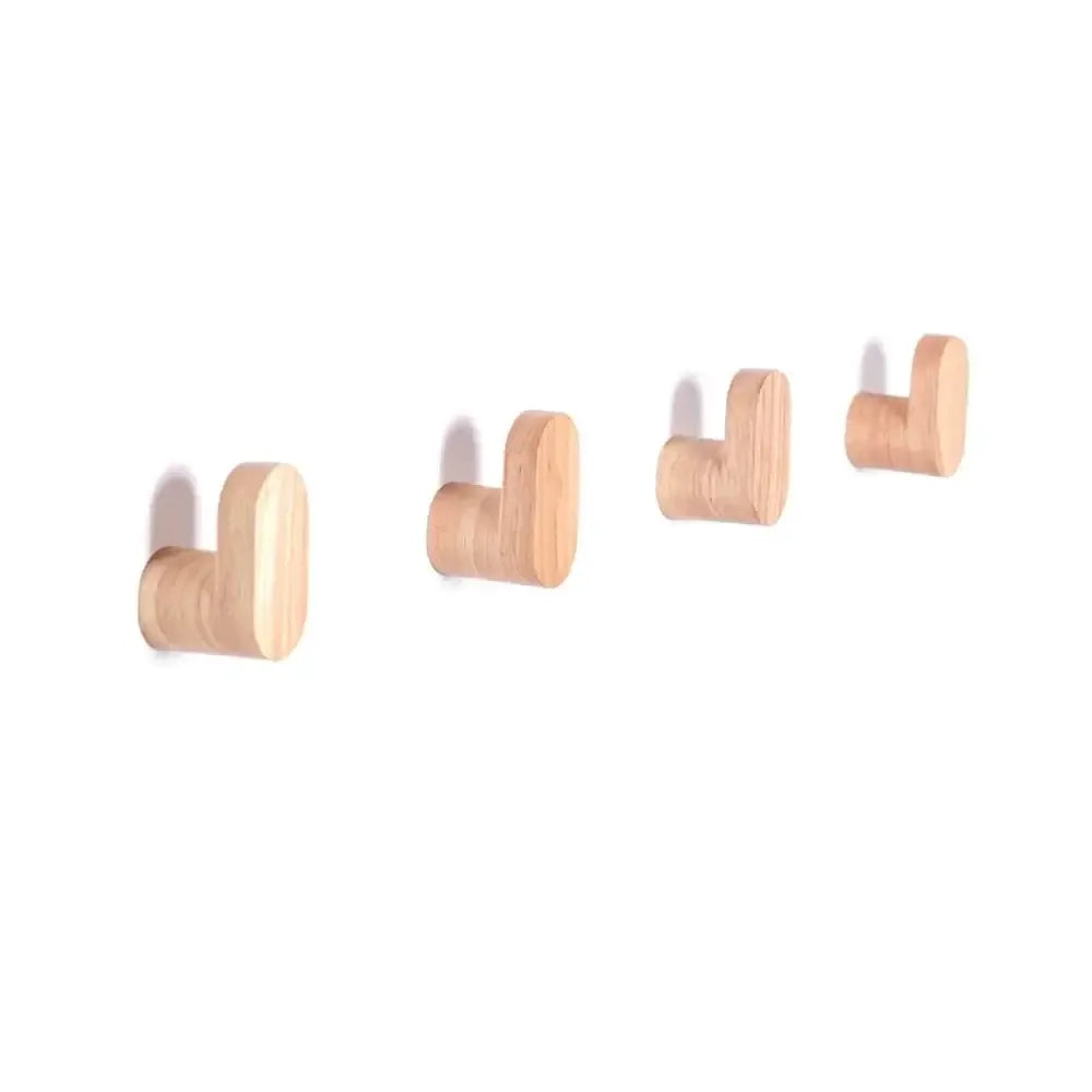 Cuatro colgadores de pared minimalistas en madera clara natural, con diseño en forma de L y acabado suave.