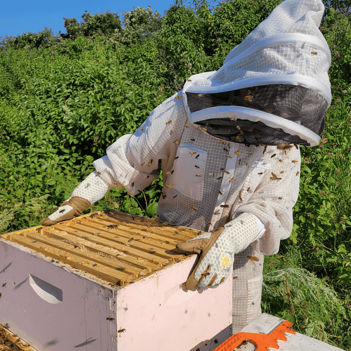 Heavy-duty beekeeping gloves with tan leather hands and breathable, patterned white fabric cuffs.