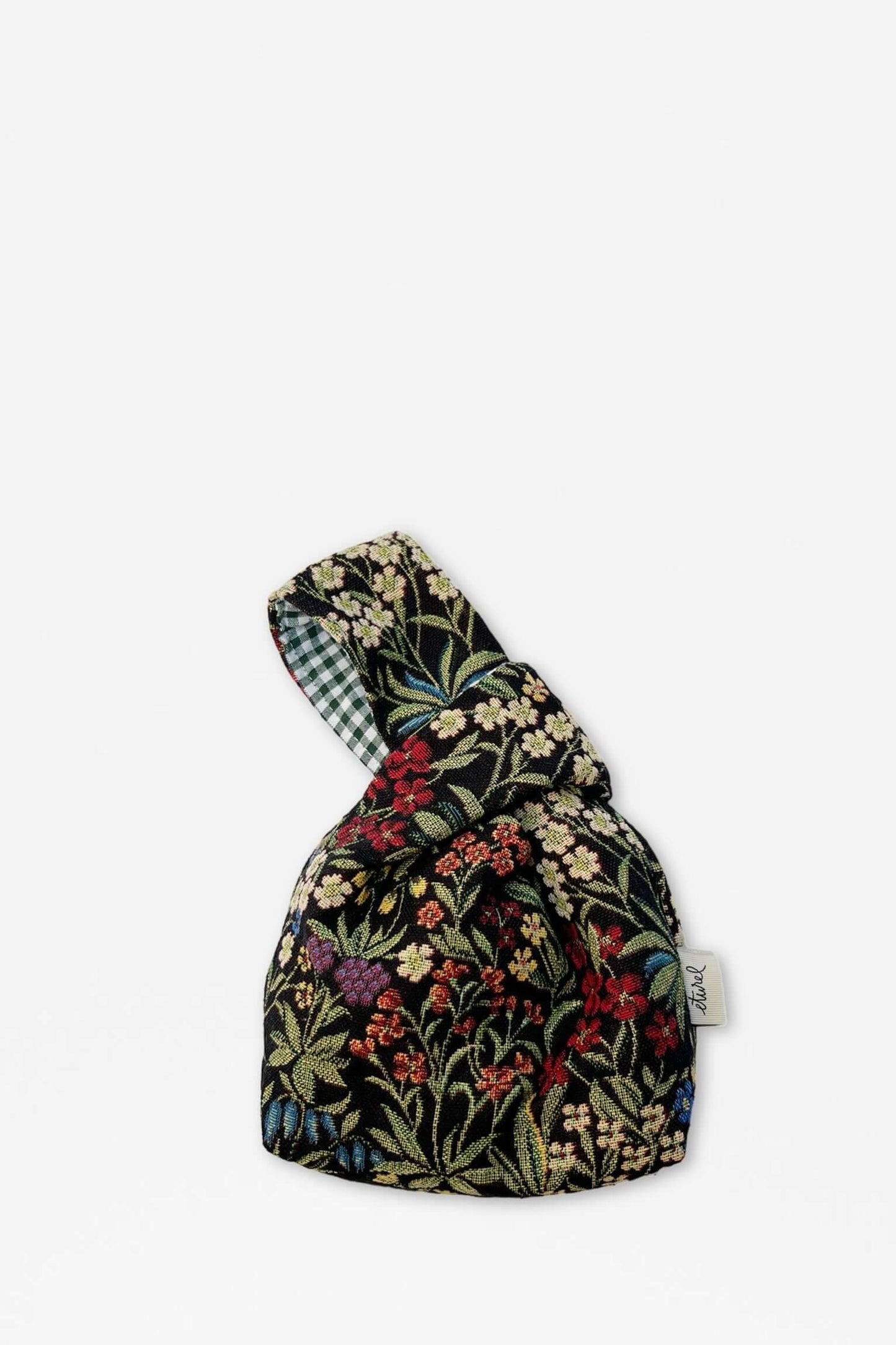 Bolso hatillo mini de tejido jacquard negro con estampado floral multicolor y forro interior a cuadros verdes y blancos.